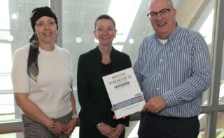 Three people holding a book