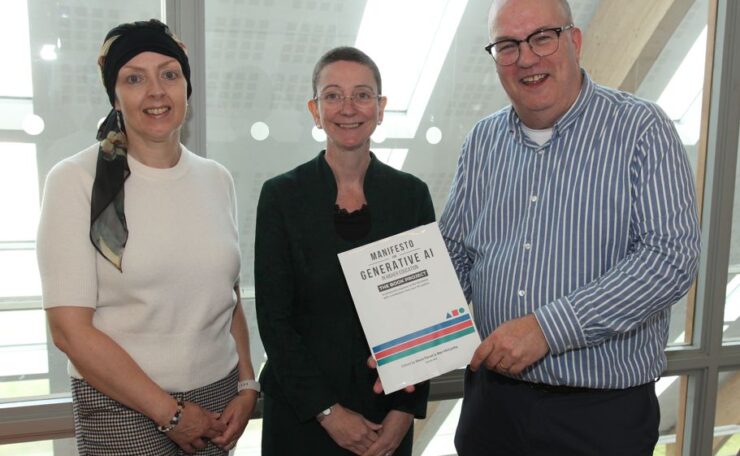 Three people holding a book